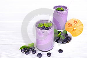 Blueberry smoothies fruit juices and blueberries on a white wooden backgroun. Drink in the morning for good health.