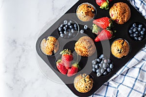 Blueberry and strawberry muffins with berries. Top view and copy space