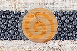 Blueberry strip with wooden disk in center for copy space