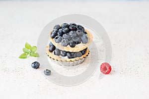 Blueberry tart with cream, cheesecake with berries on white background