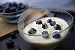 Blueberry yogurt in glass bowl on wooden table