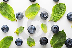 Blueberrys and leafs of mint on white background.