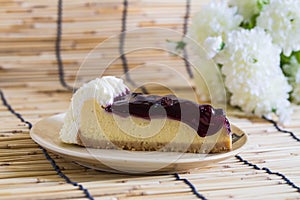 Blueberyy cheesecake on the wooden background with beautiful white flowers