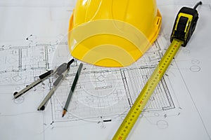 Blueprint with tape measure, pencil , thumbscrew compasses and hard hat