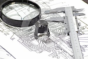 Blueprints analisys with two magnithing glasses and a calipers