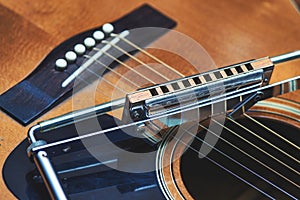 Blues harmonica resting on guitar