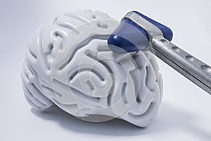 Blues head chrome neurological hammer lying on a plastic figure of a human brain with distinct convolutions. The idea of image for