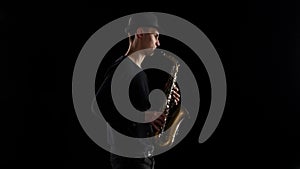 Blues in the performance young musician saxophonist. Black background studio