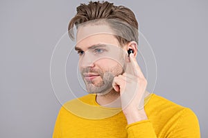 bluetooth headset device accessory. new bluetooth technology. Man point finger at wireless earbud