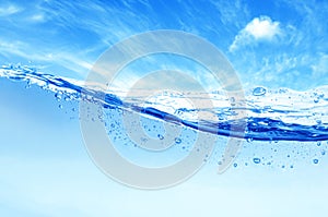 Bluewater wave surface with bubbles of the air on sky background