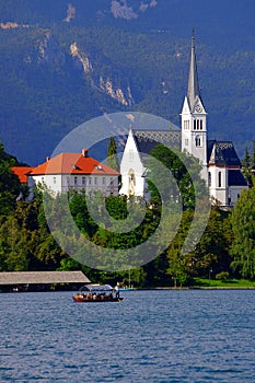 Bluish-green Lake Bled with traditional boat called pletna photo