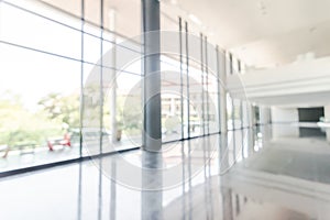 Blur background interior view looking out toward to empty office lobby and entrance doors and glass curtain wall