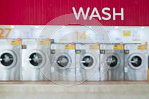 Blur background of qualified coin-operated washing machines in a public store.