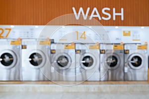 Blur background of qualified coin-operated washing machines in a public store.