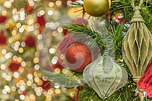 Blur bokeh background of Christmas tree ornament lights with glitter decoration balls in foreground