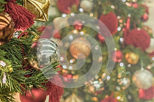 Blur bokeh background of Christmas tree ornament lights with glitter decoration balls in foreground