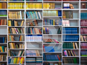 Blur books on wooden bookshelf in university or public library room or book store, abstract blur background.concept for education