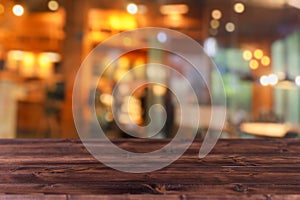 Blur coffee shop colorful dim light background on wood table space for products montage advertising