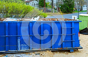 Blur dumpster, recycle waste and garbage bins near new construction site of appartment houses building