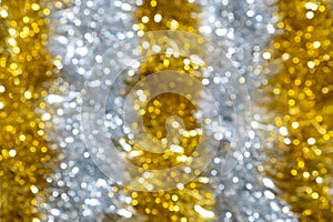 Blur golden and silver glittering tinsel.  New Year or Christmas defocused abstract background