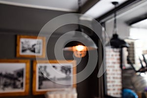 Blur image - Defocus or out of focus black lamp on the ceiling, sitting corner in the restaurant during the daytime - Blurred