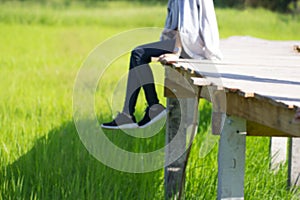 Blur image relaxes sitting hanging from edge of a wooden bridge in the countryside