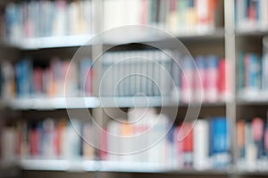 Blur image of shelf with books in library. Background