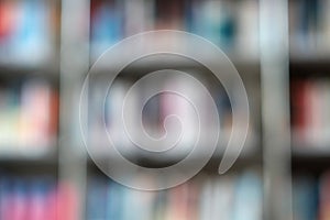 Blur image of shelf with books in library. Background