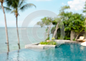 Blur image of swimming pool with tropical sea view background