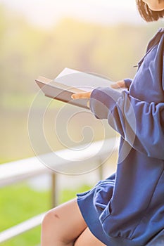 Blur image , A young woman is reading and learning the teachings of God from the Bible that she holds in her hand, with faith and