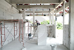 blur labor working in new house structure use lightweight cement brick and white lintel plaster to joint for reinforce in site.