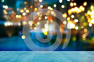 Blur light of bar or pub beside blue water swimming pool summer party at night with top of wood table background