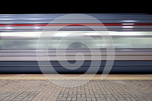 Blur motion of passenger train fast running beside railroad platform