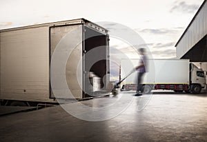 Blur Motion of Workers Unloading Cargo Pallets to The Cargo Container Trucks. Loading Dock. Shipping Warehouse. Delivery. Shipment