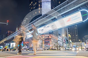 Blur pedestrians crossing busy zebra crossing road at night photo