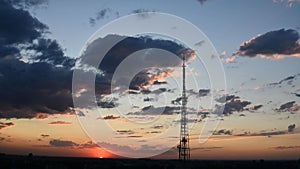 Blur silhouette of communication tower with sunset cloudscape skyline photo