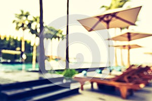 Blur summer background poolside party with blurry tropical resort hotel swimming pool place
