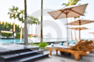 Blur summer background poolside party with blurry tropical resort hotel swimming pool place