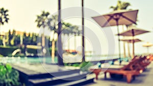 Blur summer background poolside party with blurry tropical resort hotel swimming pool place