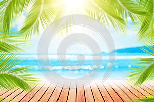 Blur tropical beach with bokeh sun light wave and palm tree on empty old wood table abstract background