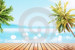 Blur tropical beach with bokeh sun light wave and palm tree on empty old wood table abstract background