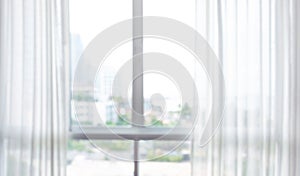 Blur of white curtain on window with city view background