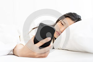 Blur Woman woke up by smartphone alarm clock and turning off snoozing phone alarm clock. photo