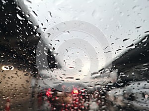 Blured background with rains drop on glass and cars on the road, Road view through car window blurry with rain and traffic jam in