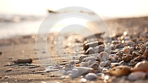Blured bokeh nature sea beach tropical background in morning sunlight. Shimmering sea wave foams wash up on sand beach with sea