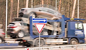 Blured truck is carried new cars on the platform