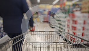 Blurred abstact background of shopping cart in supermarket . Blurry view inside department store with shopping trolley.