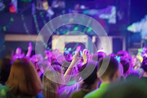 Blurred abstract background of people fans on live music festival concert, neon light