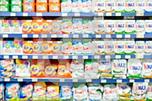 Blurred abstract bleach, fabric softener, laundry detergent, all purpose cleaners shelves in modern grocery retail store