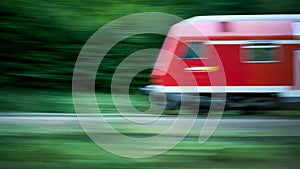 Blurred Abstract Photo of a Speeding Red Train with Foliage Background photo